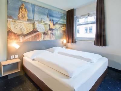 Hotelzimmer mit Doppelbett und Fenster